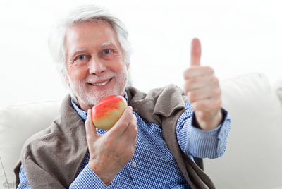 Man eating an apple while giving a thumbs up