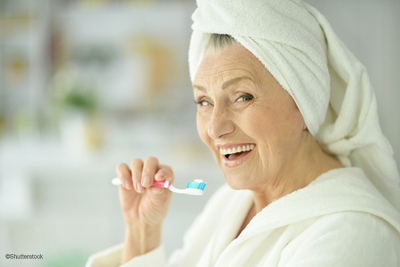 elderly woman brushing her teeth