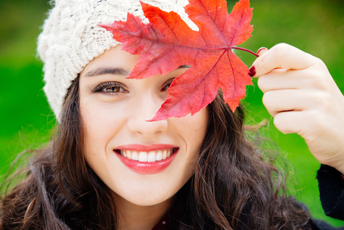 Woman holding a large maple leaf