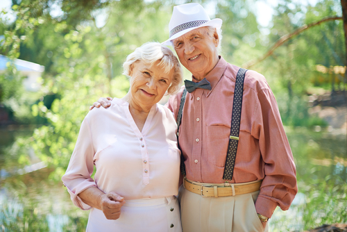Elderly couple standing in sunlight in the summer