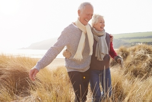 Elderly couple smiling while walking outside