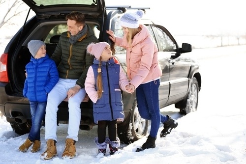 family bundled up out in the snow weather